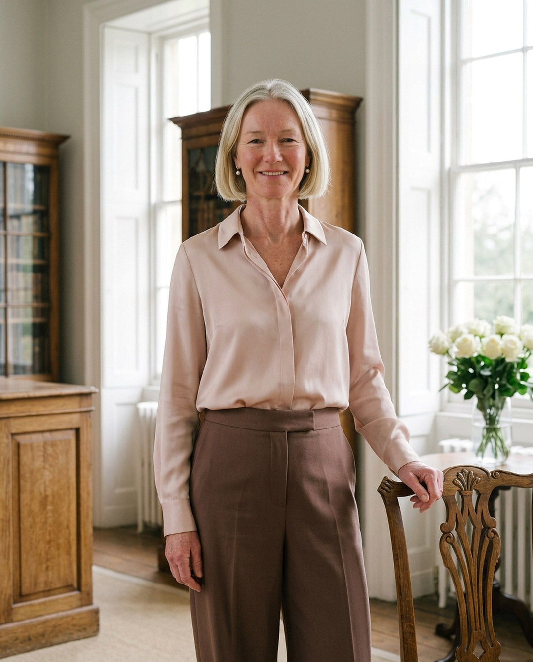 Margot in a blush blouse and cocoa trousers