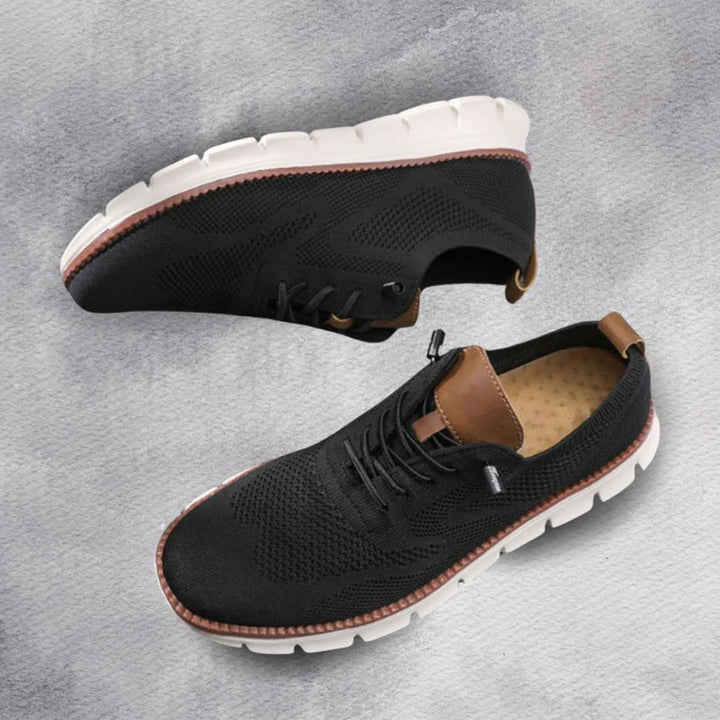 Pair of black knit trainers with white soles shown from above and the side