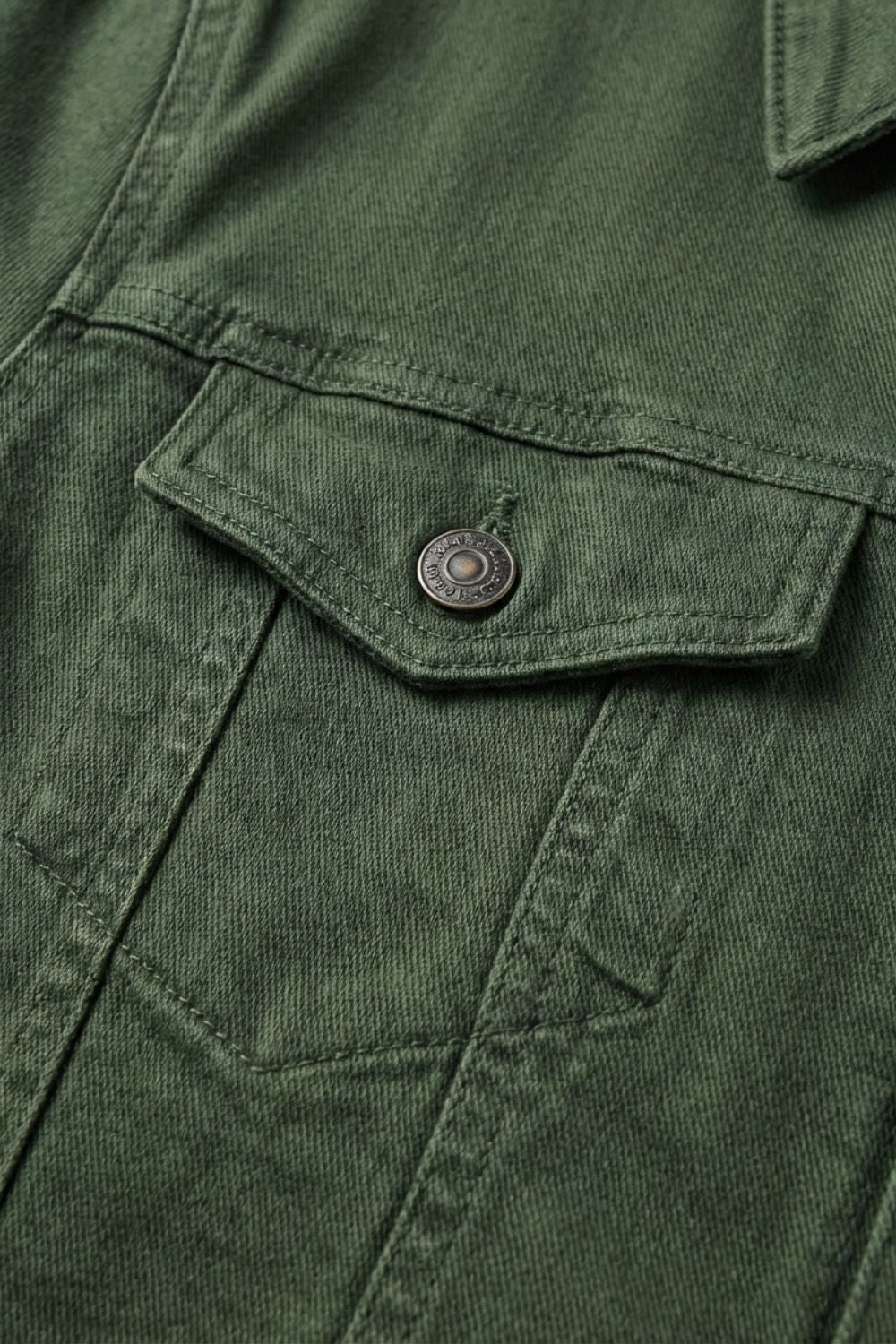 Close-up of the buttoned flap chest pocket in olive green