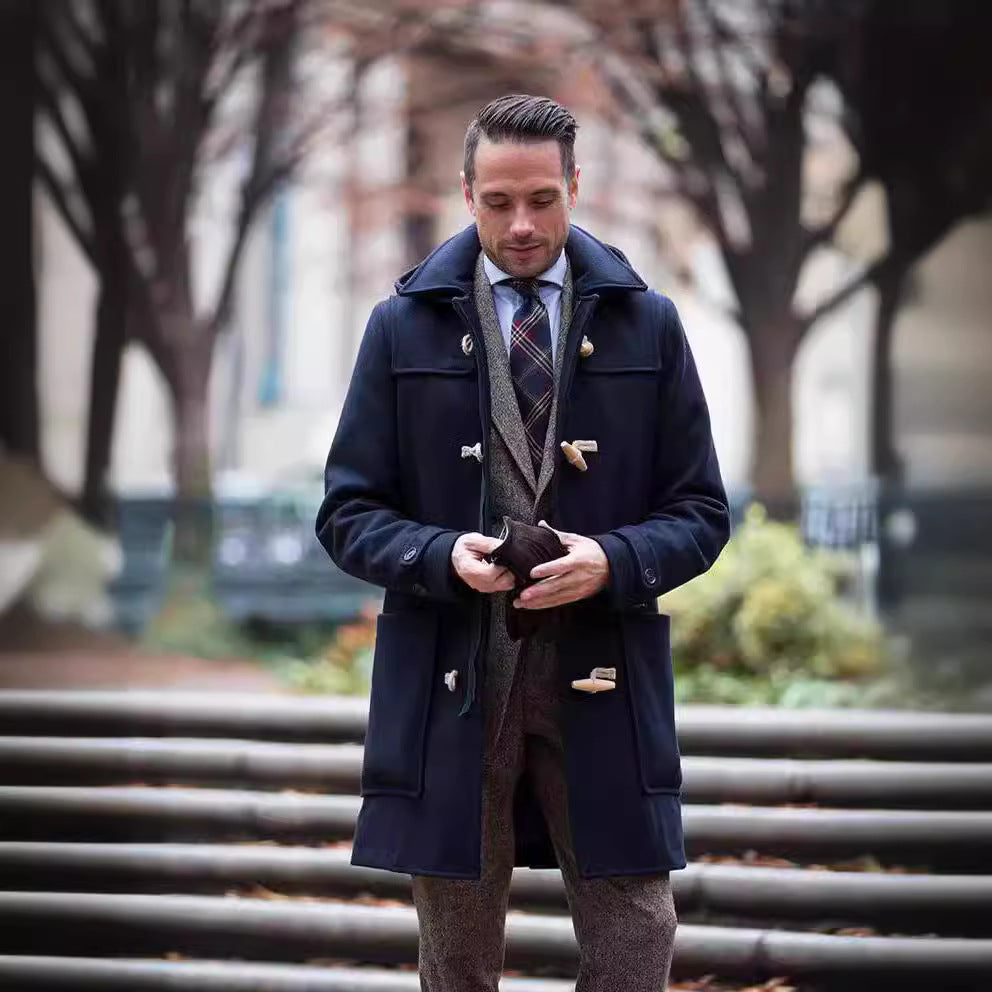 Navy duffle coat worn over a tweed blazer outdoors
