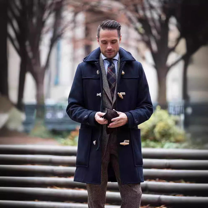 Navy duffle coat worn over a tweed blazer outdoors