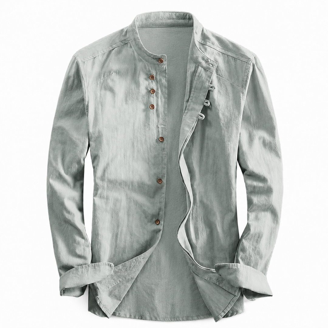 Sage green long sleeve shirt with a stand-up neckline and brown buttons laid flat