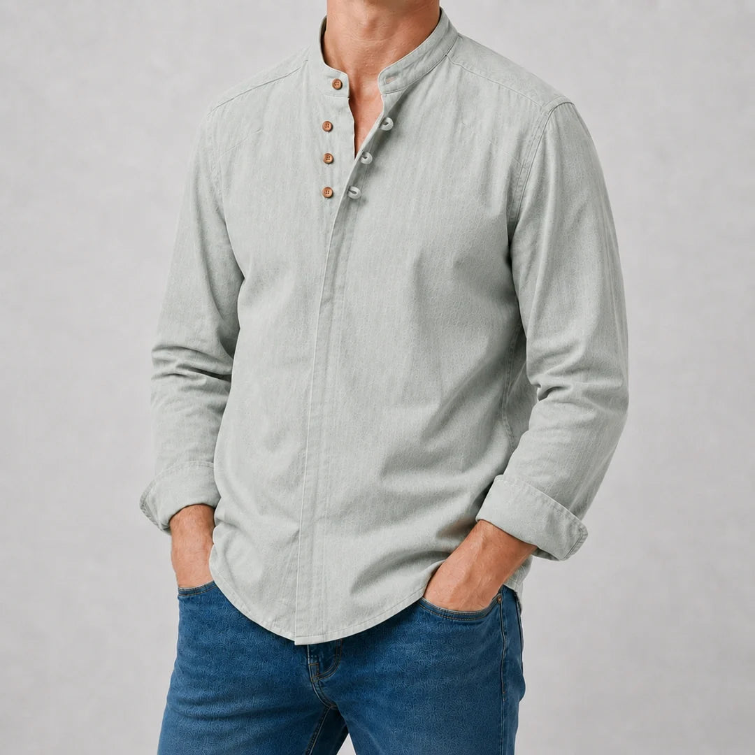 Sage green long sleeve shirt worn buttoned with the sleeves rolled back and hands in pockets