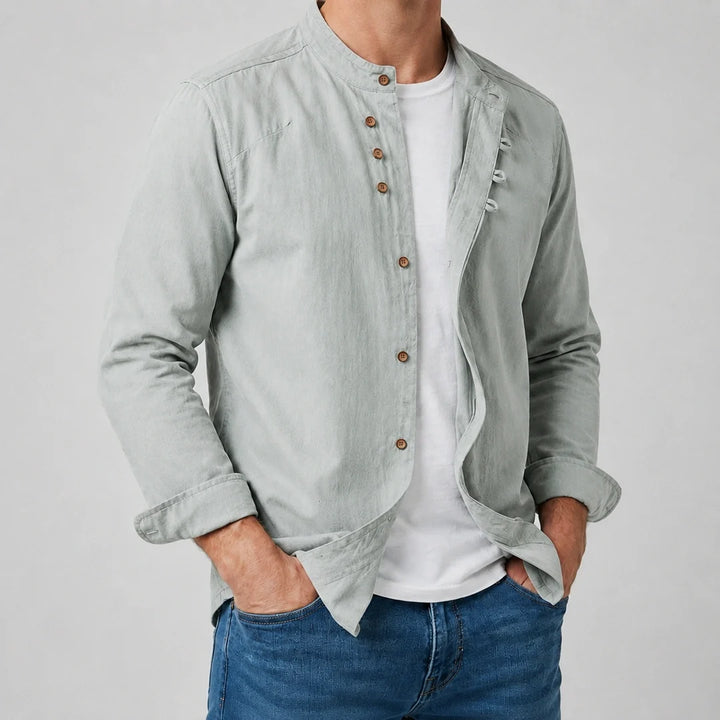 Men's grandad collar shirt in sage green worn open over a white tee with denim