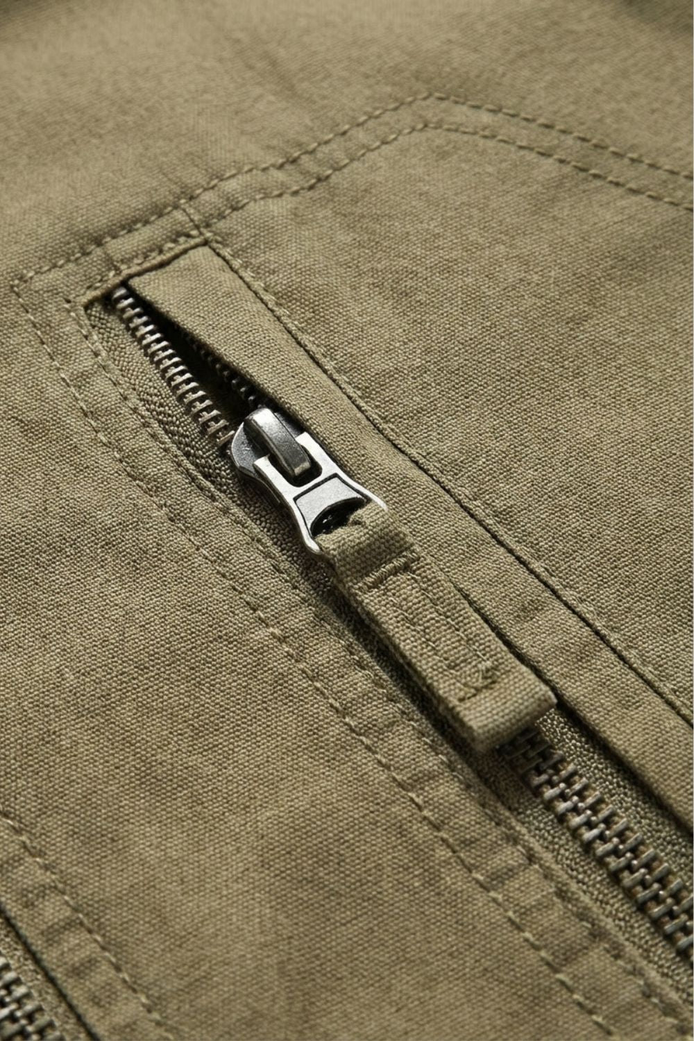 Close-up of the zipped chest pocket on the khaki jacket