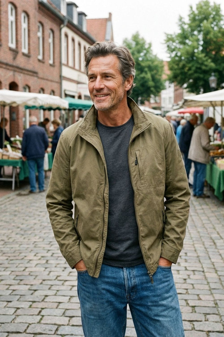 Man wearing the khaki jacket open over a grey tee at a street market
