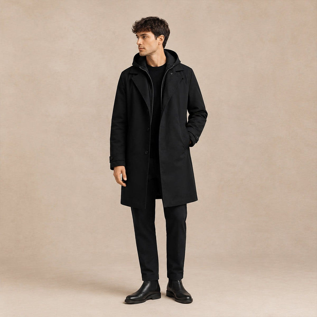 Model wearing the black hooded parka coat over dark trousers