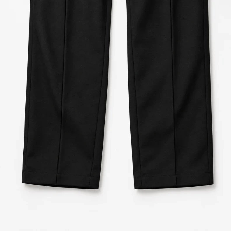 Black straight legs laid flat showing the pintuck seams and open hems