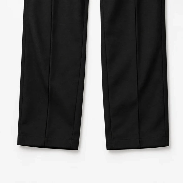 Black straight legs laid flat showing the pintuck seams and open hems