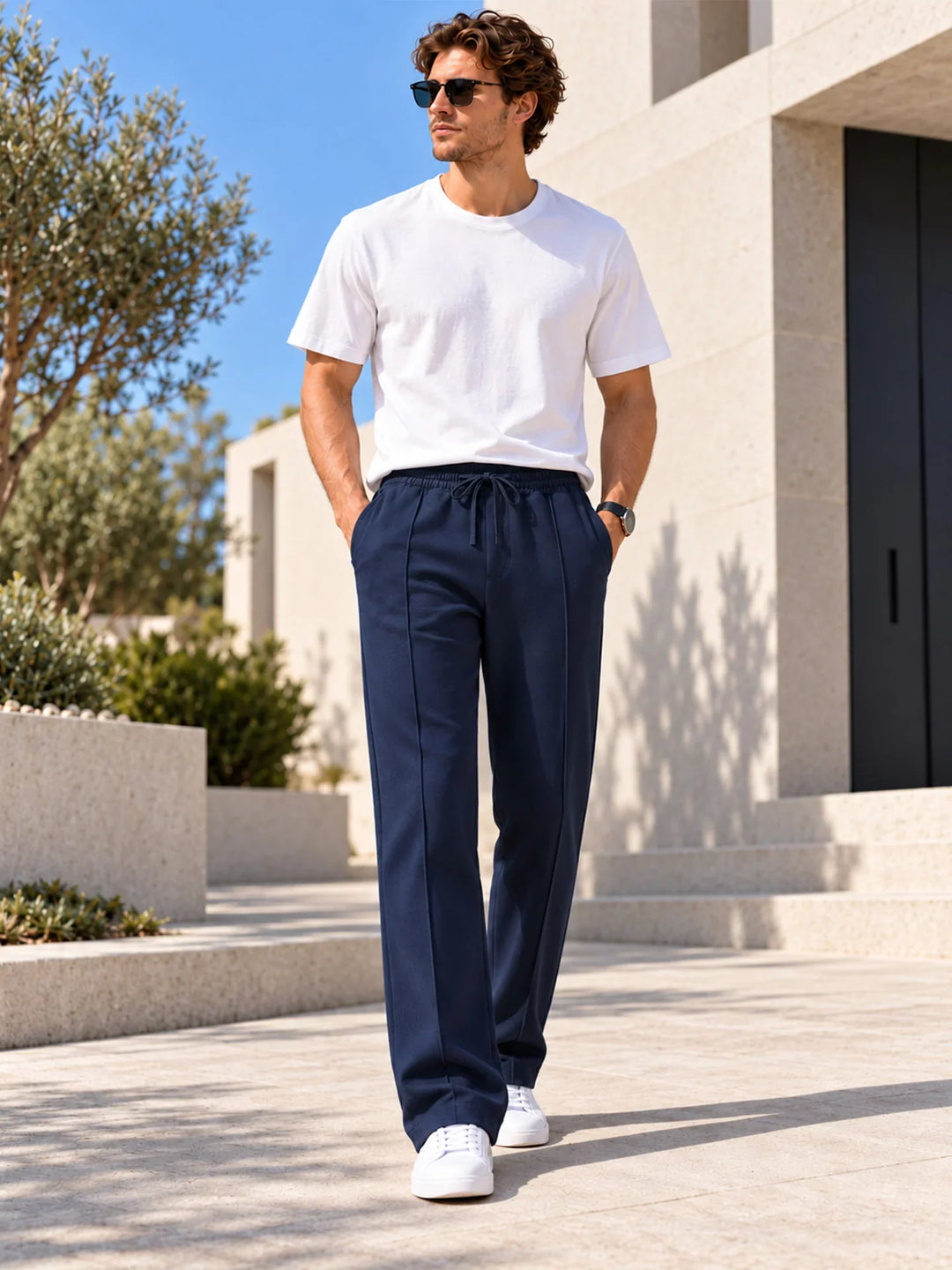 Navy straight leg joggers worn with a white t shirt and sunglasses