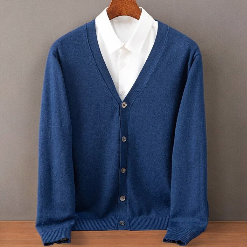 Royal blue V neck cardigan on a hanger over a white shirt