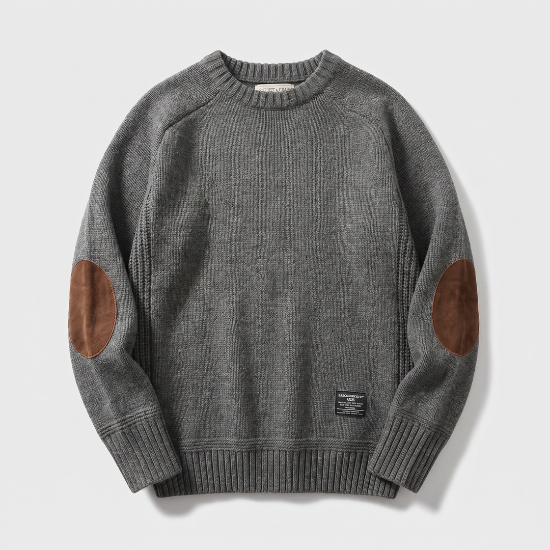 Grey knitted crew neck jumper laid flat with tan elbow patches