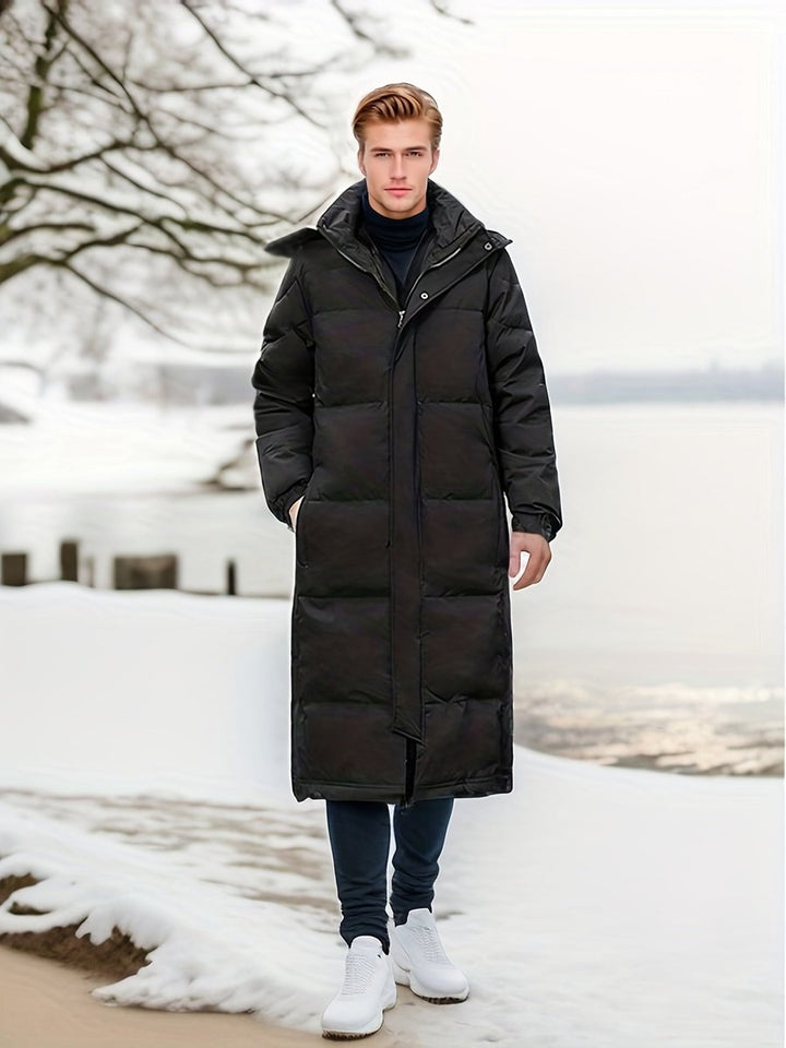 Black hooded puffer coat worn on a snowy beach