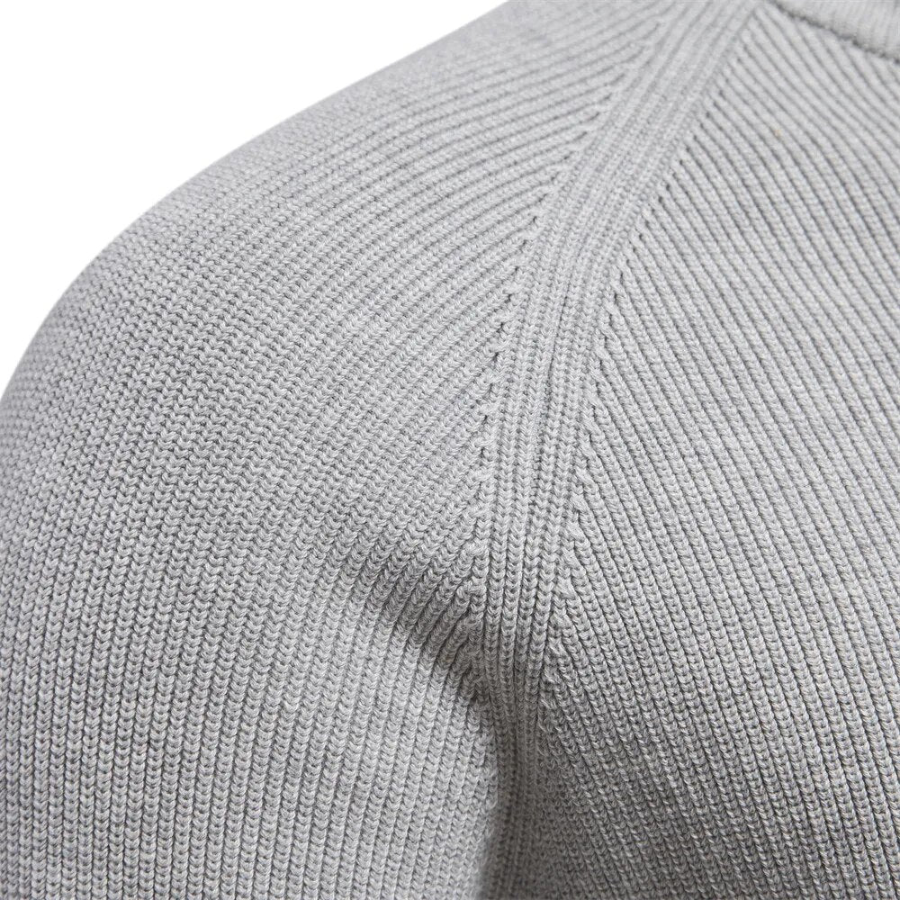 Close up of the raglan shoulder seam on the light grey ribbed knit