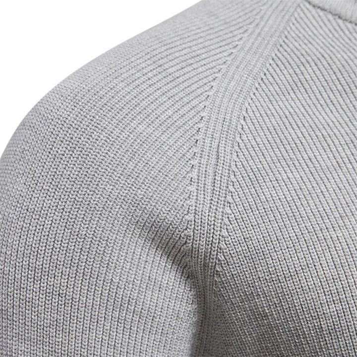 Close up of the raglan shoulder seam on the light grey ribbed knit