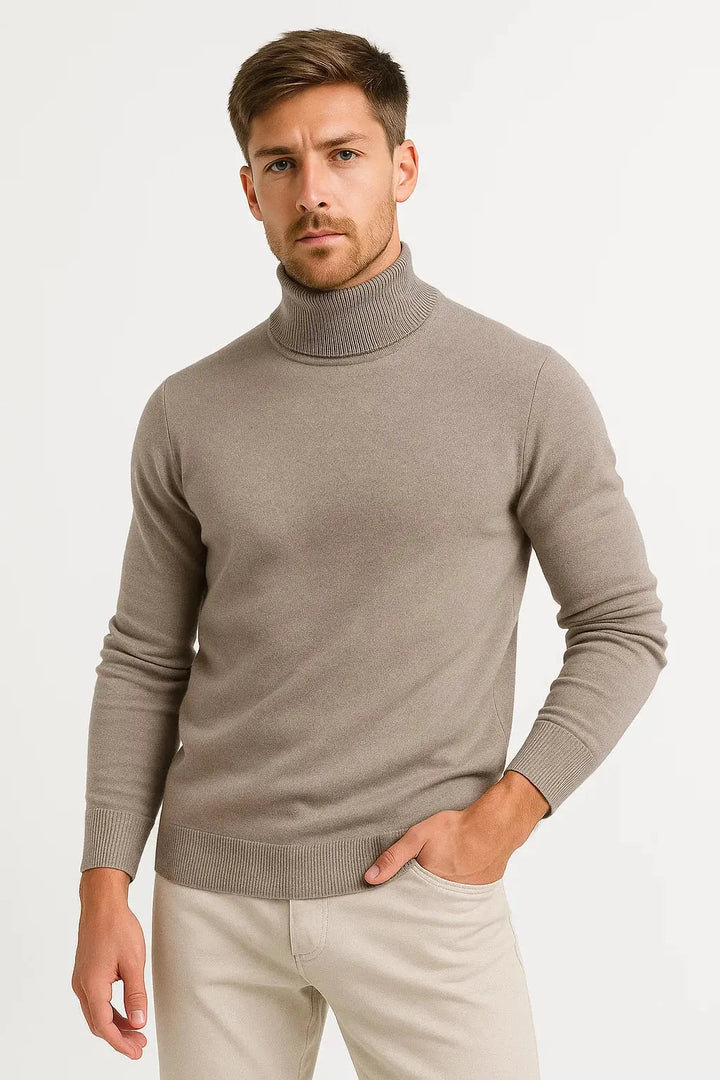 Man in a taupe roll neck jumper with one hand in his trouser pocket