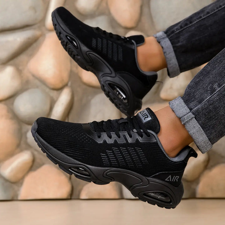 Black trainers, worn on foot, front view