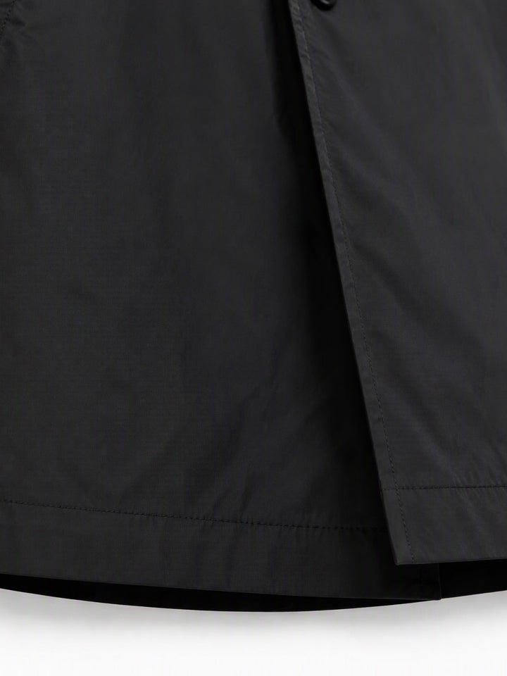 Close-up of the black coat fabric and the lower front edge