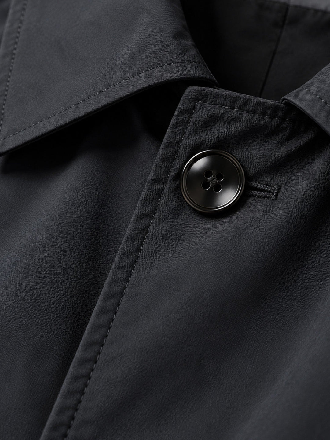 Close-up of the black coat collar and a button on the front