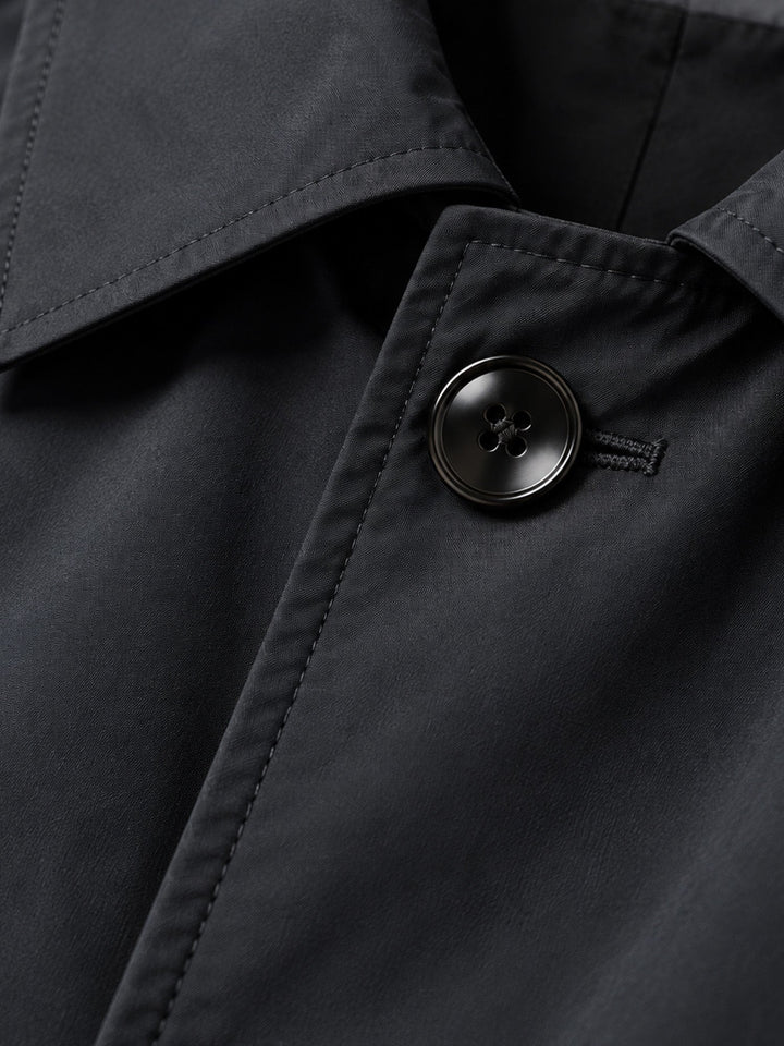 Close-up of the black coat collar and a button on the front
