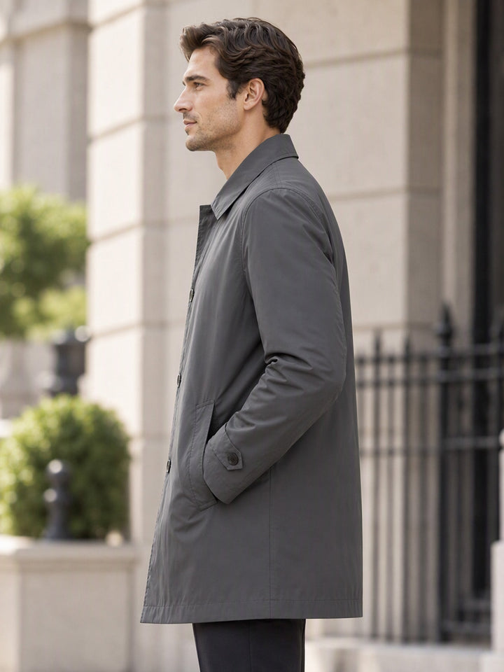 Side view of a grey single breasted coat beside black railings