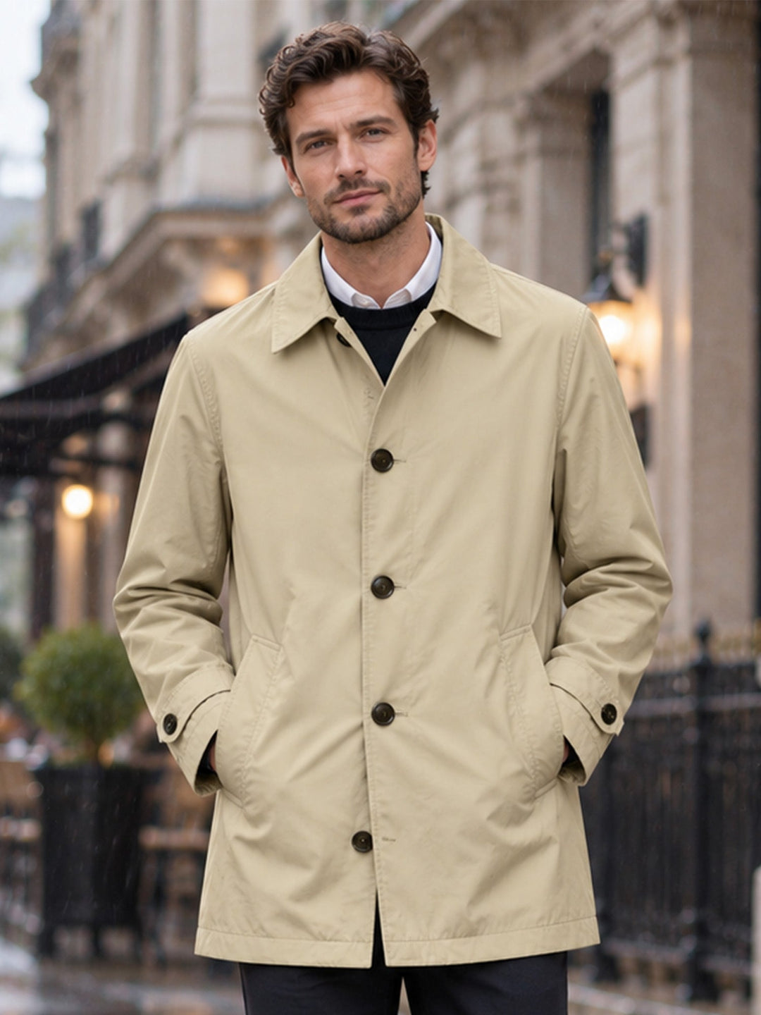 Khaki single breasted mac coat worn over a white shirt on a city street