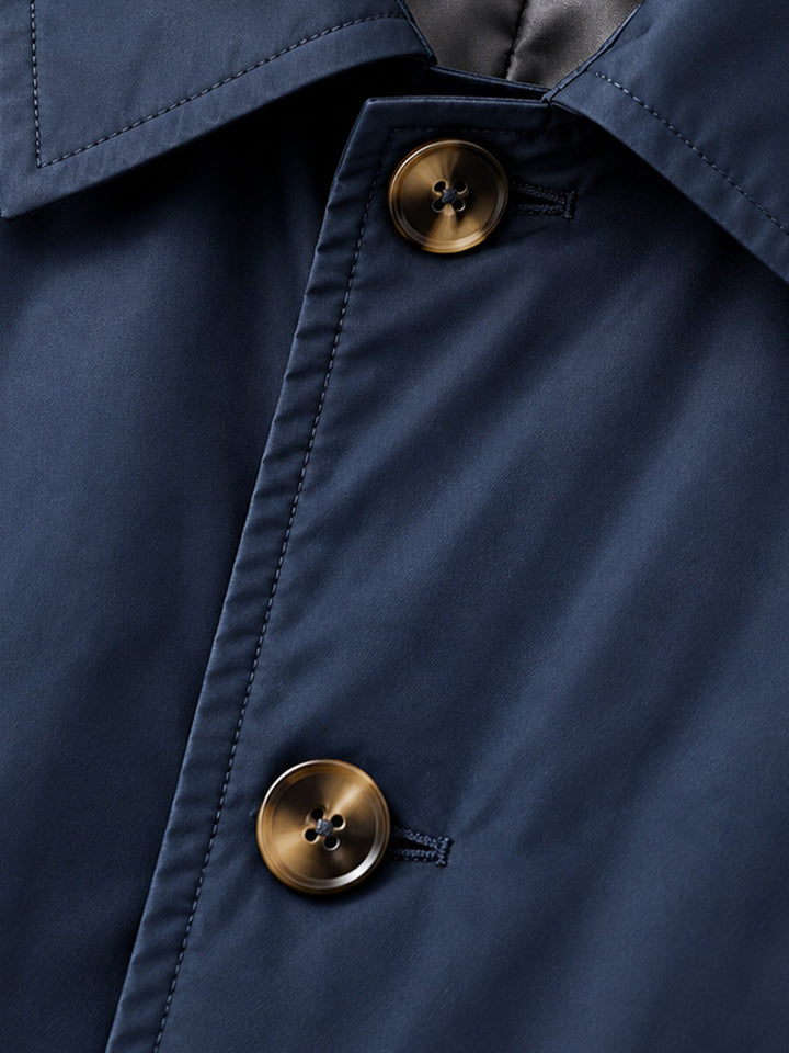 Close-up of the navy coat collar edge and dark buttons