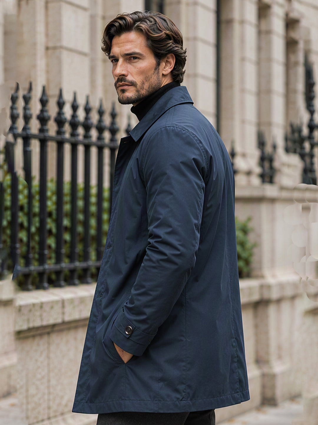 Man in a navy mid length coat seen from the side outside a townhouse
