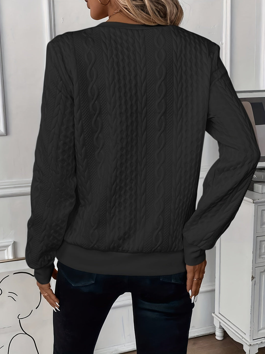 Back view of the black cable knit jumper with ribbed hem