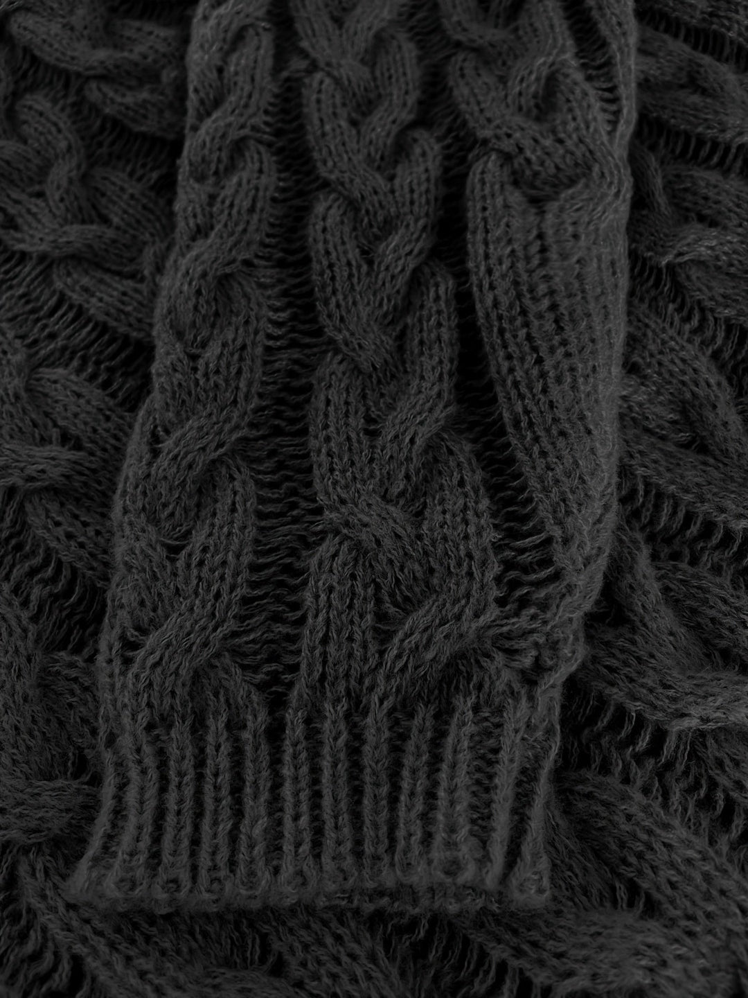 Close up of the black cable knit texture and ribbed cuff