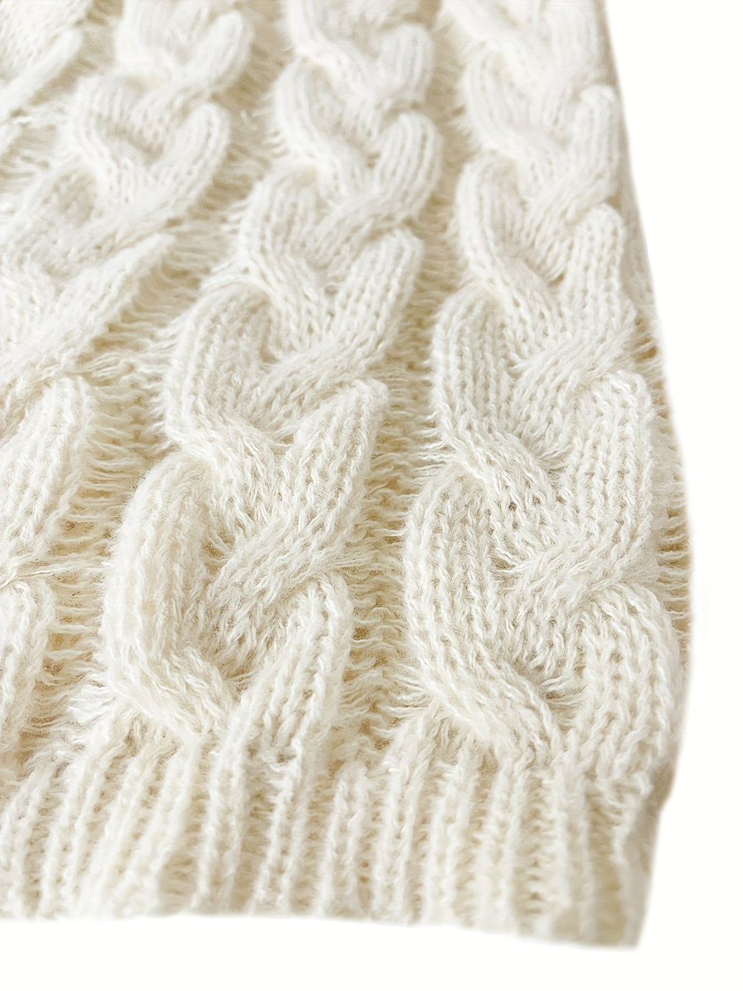 Cream jumper hem with chunky cable twists and a ribbed edge