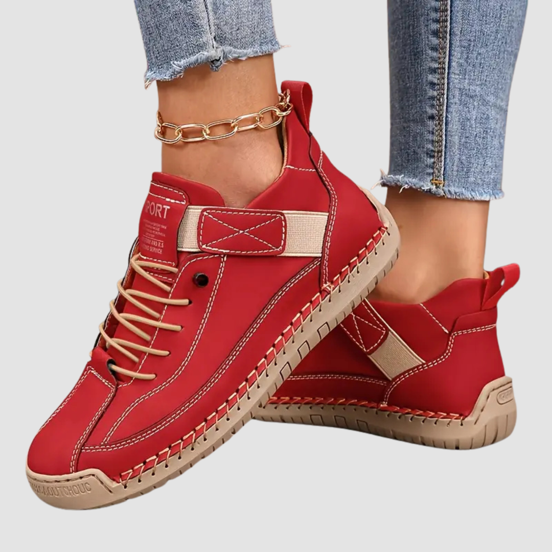Red lace-up trainer with a cream strap and a stitched sole edge