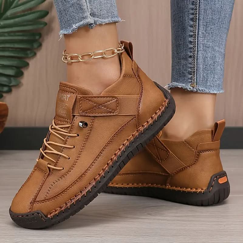 Tan lace-up trainer with a strap and stitched sole edge, worn with cropped trousers