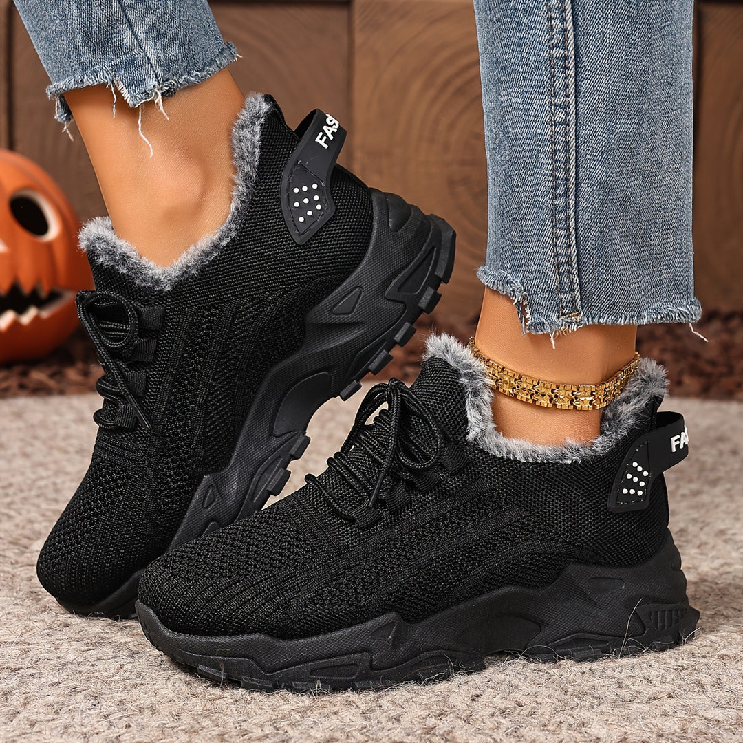 Black trainers, worn on foot, side view