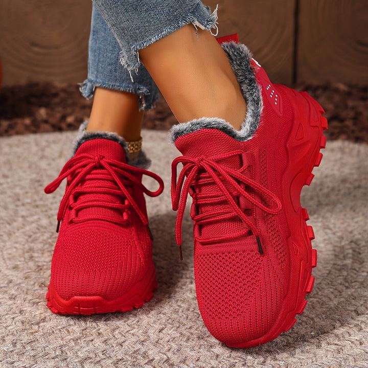 Red trainers, worn on foot, front view