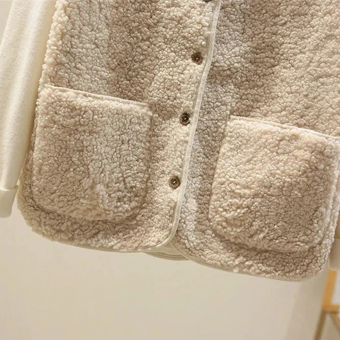 Close-up of the patch pockets and buttons on the beige teddy gilet