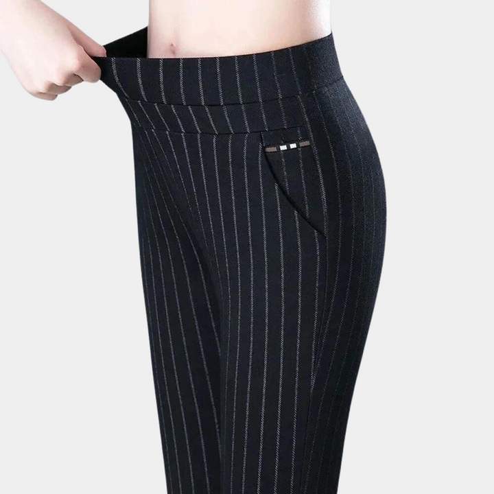 Black pinstripe leggings pulled at the stretchy waistband to show the fit