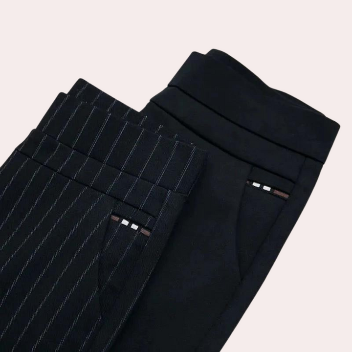 Folded black and pinstripe leggings showing the wide waistband and pocket trim