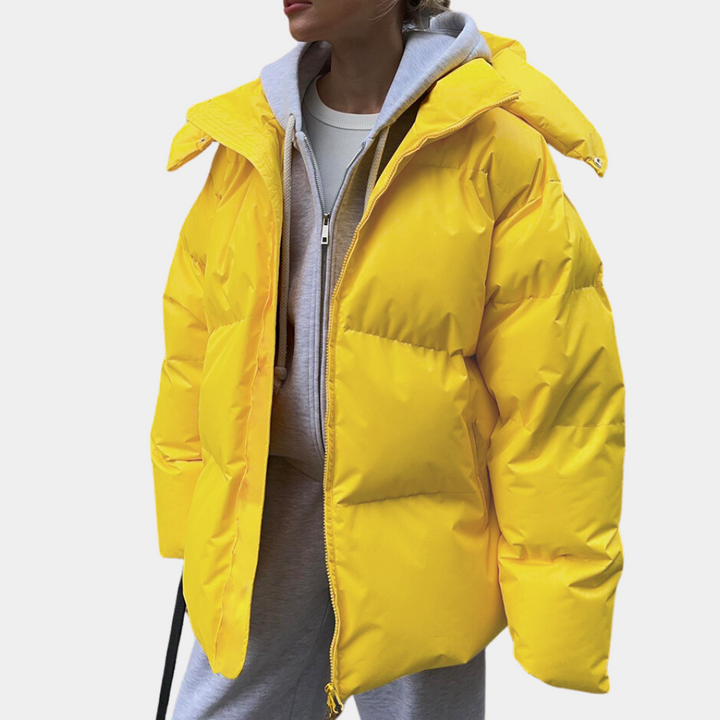 Yellow oversized puffer jacket worn open over a grey hoodie