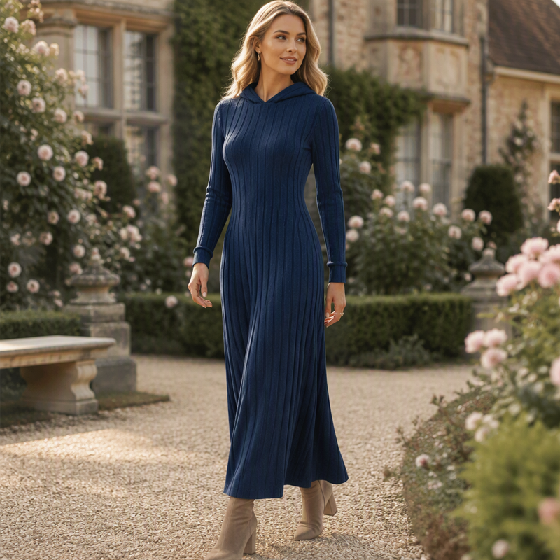 Navy blue floor length knit dress with hood worn in a garden courtyard