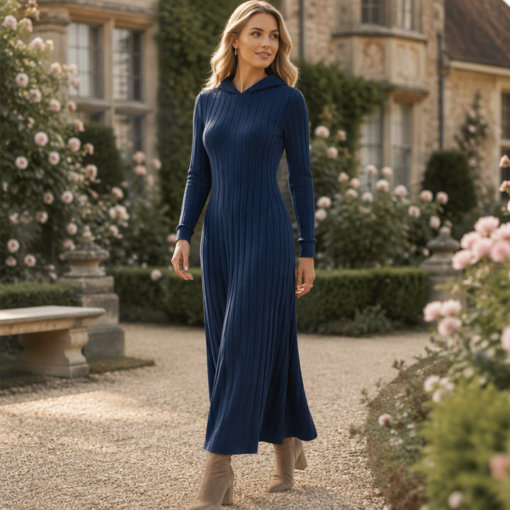 Navy blue floor length knit dress with hood worn in a garden courtyard
