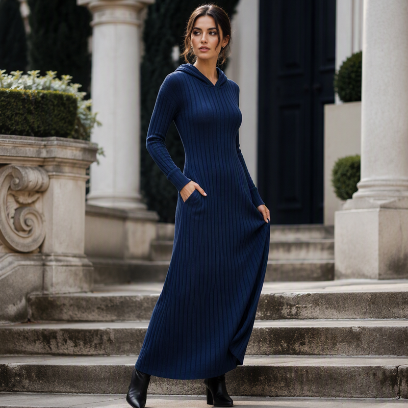 Navy blue ribbed hooded maxi dress with side pockets, worn on stone steps