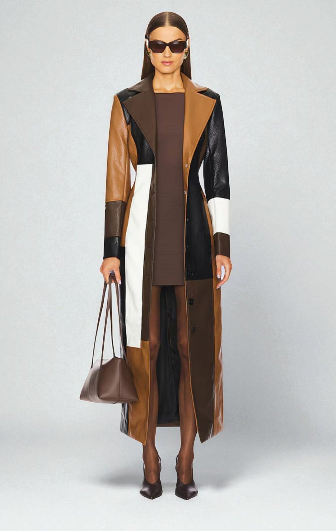 Women's long coat in brown patchwork, fitted with wide lapels, worn open over a brown dress