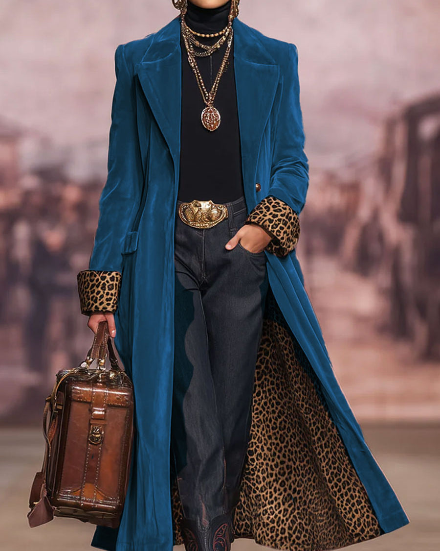 Blue long tailored coat with a leopard print lining and cuffs worn with dark trousers and boots