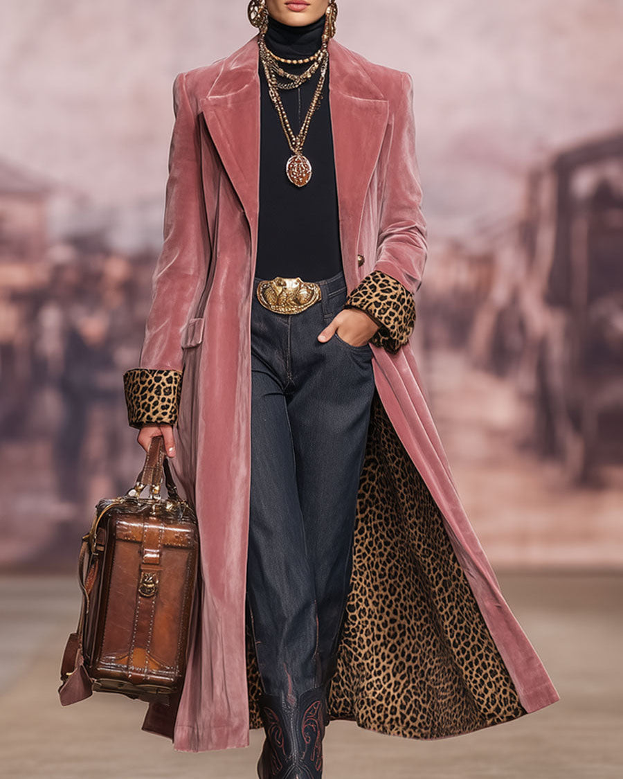Pink longline tailored coat worn open over a black polo neck and dark trousers