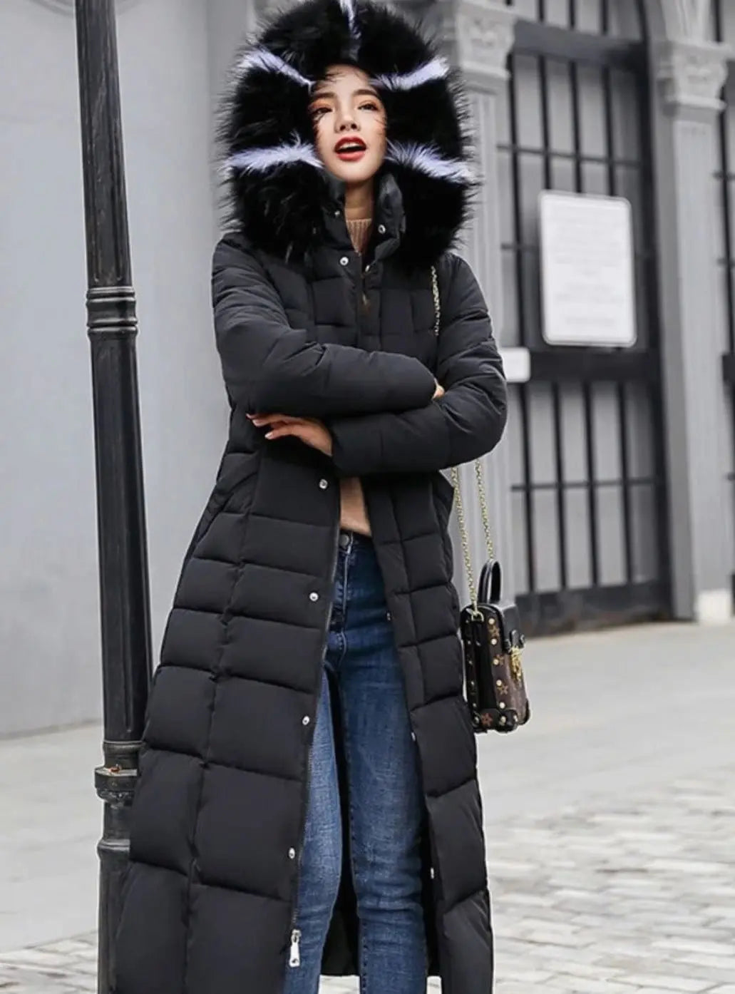 Black long puffer coat with the fur trimmed hood up