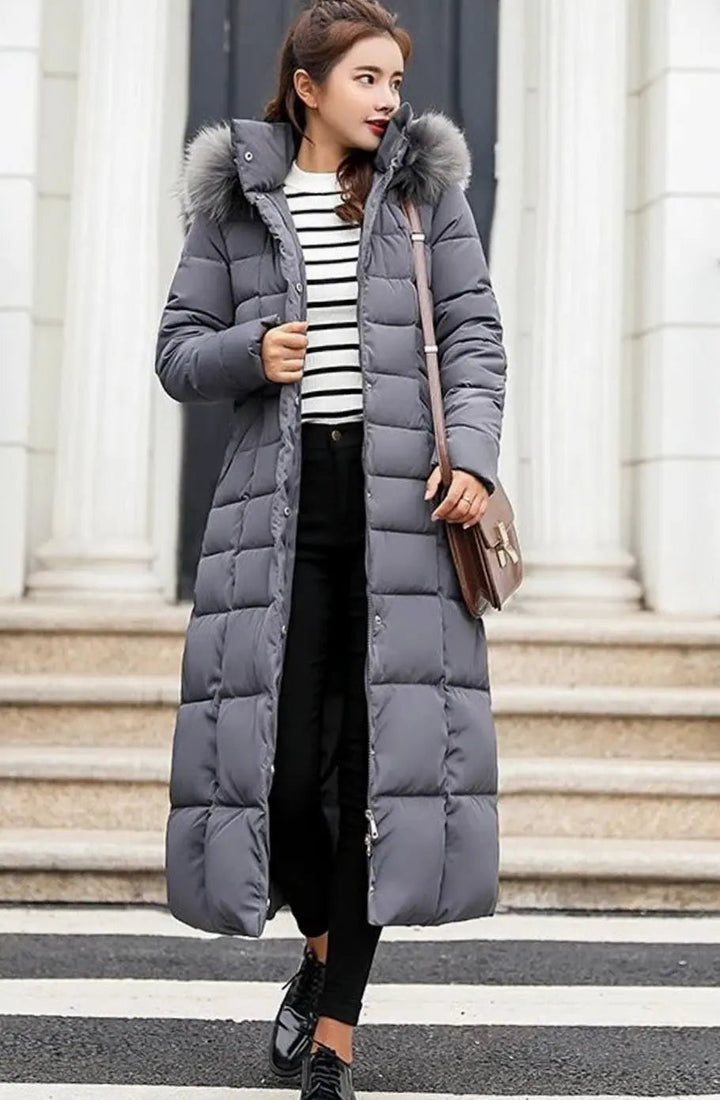 Dark grey quilted long coat worn open over a striped top
