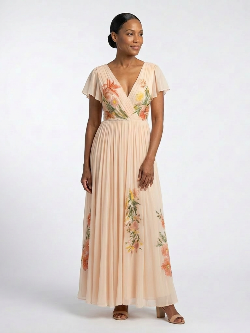 Peach embroidered dress with wrap V neckline worn by a model with dark hair