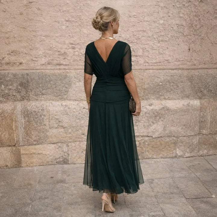 Back view with the deep V back and sheer sleeves in dark green
