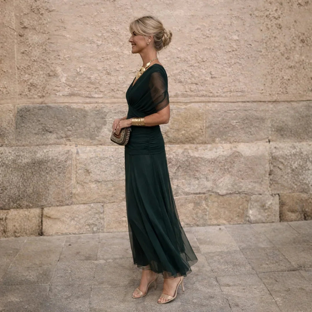 Side view of the dark green dress showing the gathered waist and ankle length